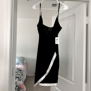 The holiday is coming pretty black dress with rhinestones on it .